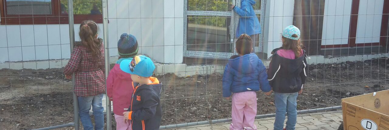 Kinder stehen vor einer Baustelle
